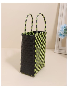 Detailed view of neon green and black checkered woven tote bag with sturdy top handles
