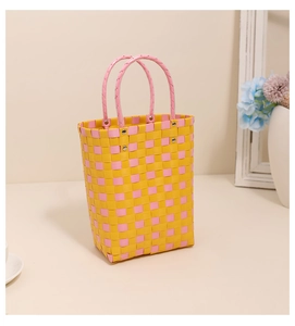 Macro detail of hand-woven plastic basket featuring pink and yellow gingham pattern