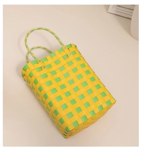 Close-up of yellow and green woven plastic tote bag with sturdy silver metal rivets