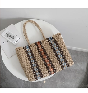 Detail of hand-woven straw tote with vertical stripes and natural fiber texture