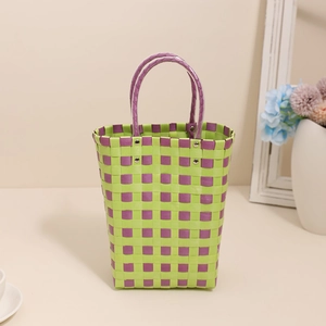 Green and purple checkered plastic woven handbag with durable round handles and metal rivets