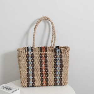 Minimalist straw tote bag with vertical stripes and fringe detail for beach vacation