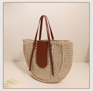 Close-up of woven straw tote bag with brown leather accents and detailed texture
