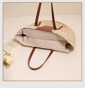 Detail view of woven tote bag showing secure zipper closure and premium brown leather handles