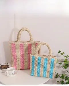 Detailed view of striped woven straw handbags in pink and blue for summer beach vacations