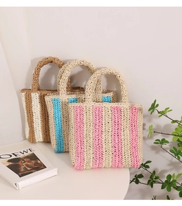Close-up of three woven straw handbags with colorful vertical stripes and textured finish