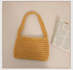 Close-up of bright yellow hand-woven cotton shoulder bag with crochet texture