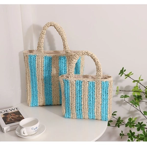 Close-up of dual-size woven straw tote bags with light blue and beige vertical stripes