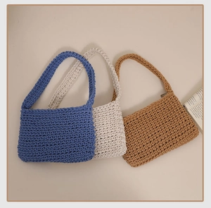Detail view of woven cotton shoulder bags in blue, cream and tan showing textures