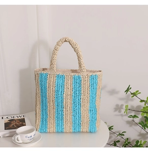 Detail of handwoven straw tote with blue stripes and handles on a minimalist display