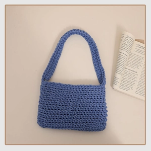 Detailed macro view of deep blue hand-woven crochet handbag with dense rope texture