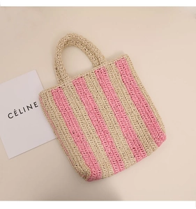 Top view of pink and beige striped woven tote bag with straw handles and summer vibes