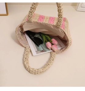 Detail view of woven straw tote bag with striped pattern, interior lining and zipper pocket