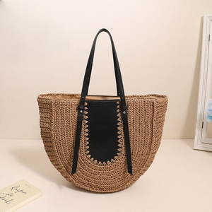 French half-moon straw tote bag with black leather patch and handles for beach vacations
