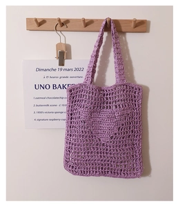 Detailed close-up of a purple crochet tote bag with openwork knit mesh texture