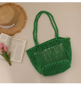 Detail of green handmade macrame beach bag with open mesh weave and thick handles