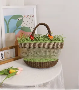 Detail der handgewebten Strohtasche mit grünen Kontraststreifen und bunten Holzperlen