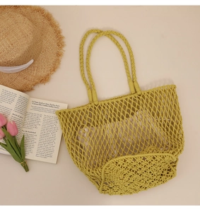 Detail of green woven mesh tote with cotton liner, straw hat and tulip beach decor