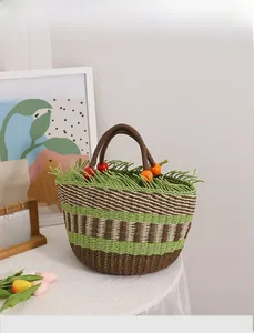 Detail der handgewebten Strohtasche mit bunten Holzperlen und Fransen am Rand