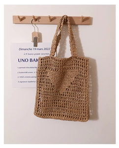 Close-up of the handcrafted woven straw pattern and texture on a beige tote beach bag