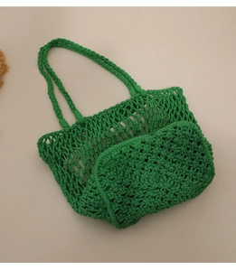 Detail of green woven cotton mesh beach bag showing handcrafted rope texture and pattern