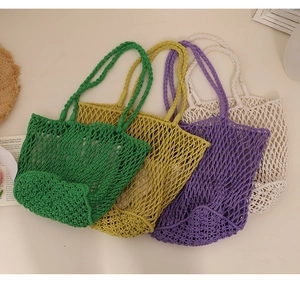 Flat lay of handmade woven cotton net bags in green, yellow, purple, and cream colors