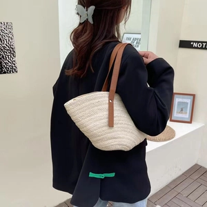 Handmade woven straw tote bag with brown leather handles for casual summer beach vacations