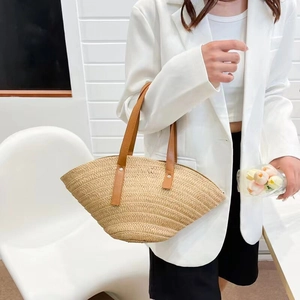 Handmade woven straw shell bag with brown leather handles for summer beach vacations