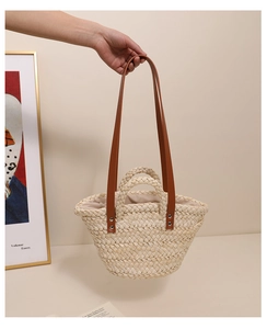 Detail of handmade corn husk woven tote with brown leather strap and fabric lining