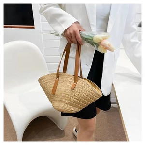 Detail of straw woven bag with brown leather handles and secure metal rivets