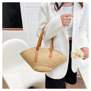 Detail of shell-shaped straw handbag with brown leather handles and tulip accessories