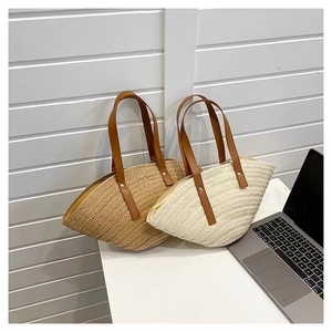 Detail of handcrafted straw tote bags with leather handles and tight woven texture
