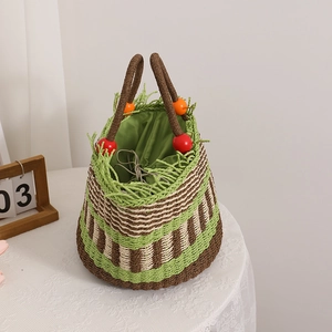 Bunte gestreifte Strohtasche mit Holzperlen und Fransenrand auf einer Spitzendecke