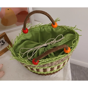 Handgefertigte Strohtasche mit bunten Holzperlen, grünen Fransen und Kordelzugfutter