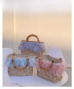 Detailed view of woven straw handbags with colorful feathers and bamboo handles