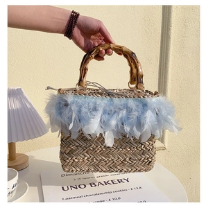 Detail of straw tote with bamboo handle, blue feathers, and polka dot drawstring lining