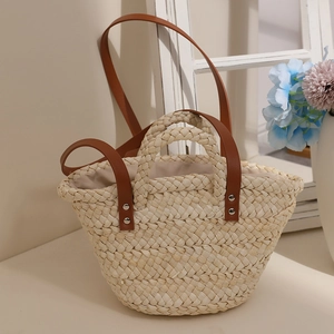 Handcrafted corn husk woven tote bag with brown leather strap for beach vacations