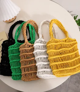Detailed view of hand-woven cotton thread beach bags in five colors on a white table