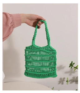 Detalle del bolso de algodón tejido a mano verde brillante con malla y asa trenzada