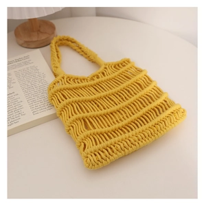 Detalle de la bolsa de red de algodón tejida a mano en amarillo sobre una mesa blanca