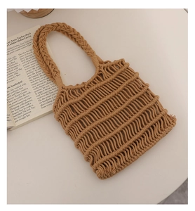 Detalle de bolso de ganchillo caqui con textura ondulada y asas trenzadas sobre mesa