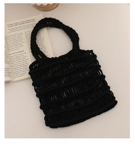 Vista detallada del bolso de macramé negro hecho a mano con un intrincado patrón de red