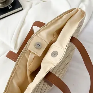 Handmade shell woven straw tote bag with brown leather handles and magnetic snap closure