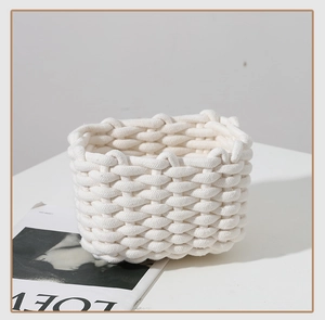 Detail of white cotton rope woven storage basket with thick texture and rounded corners