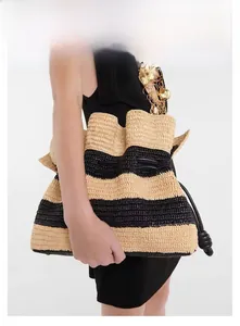 Detail of hand-woven striped straw bag with black drawstring and elegant texture