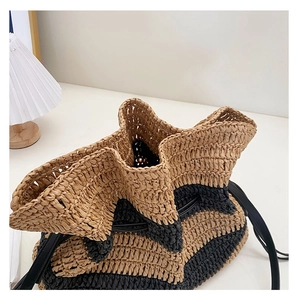 Macro detail of hand-woven striped straw bag showing wavy edge and drawstring closure