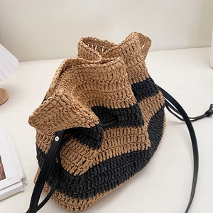 Striped straw bucket bag with black leather drawstring and shoulder strap for beach