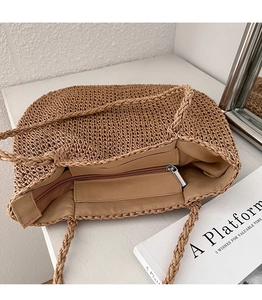 Vue de dessus d'un grand sac en paille avec fermeture éclair et doublure intérieure tissée
