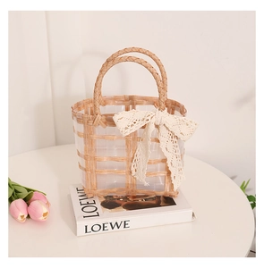 Detail showing white lace bow and transparent woven texture on the square beach bag