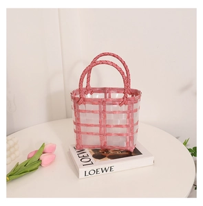 Detailed shot of pink and white checkered woven jelly basket bag on a decorative table